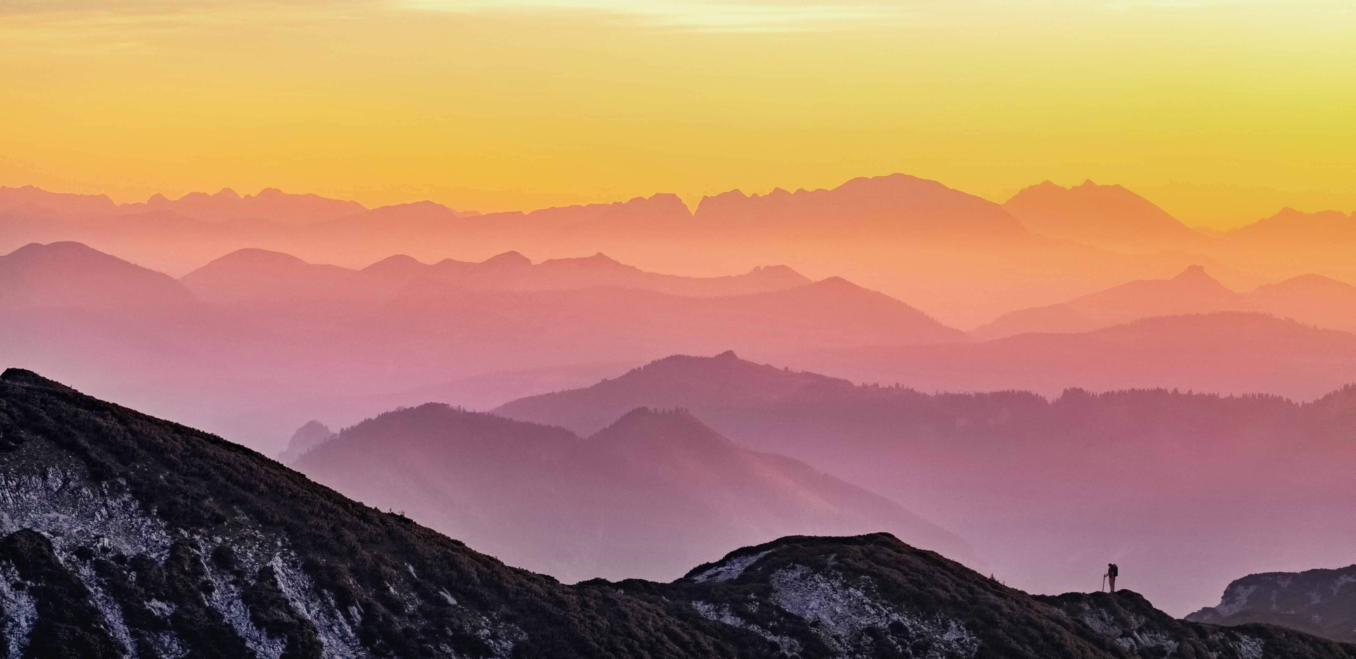 Person on a mountain with sunset
